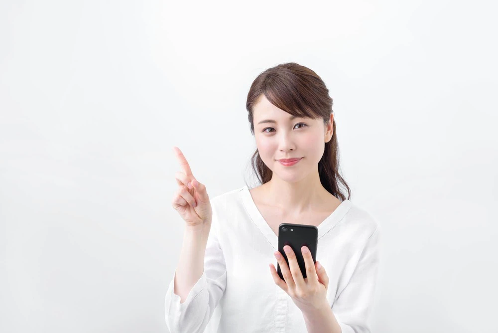 スマホを持ち解説する女性