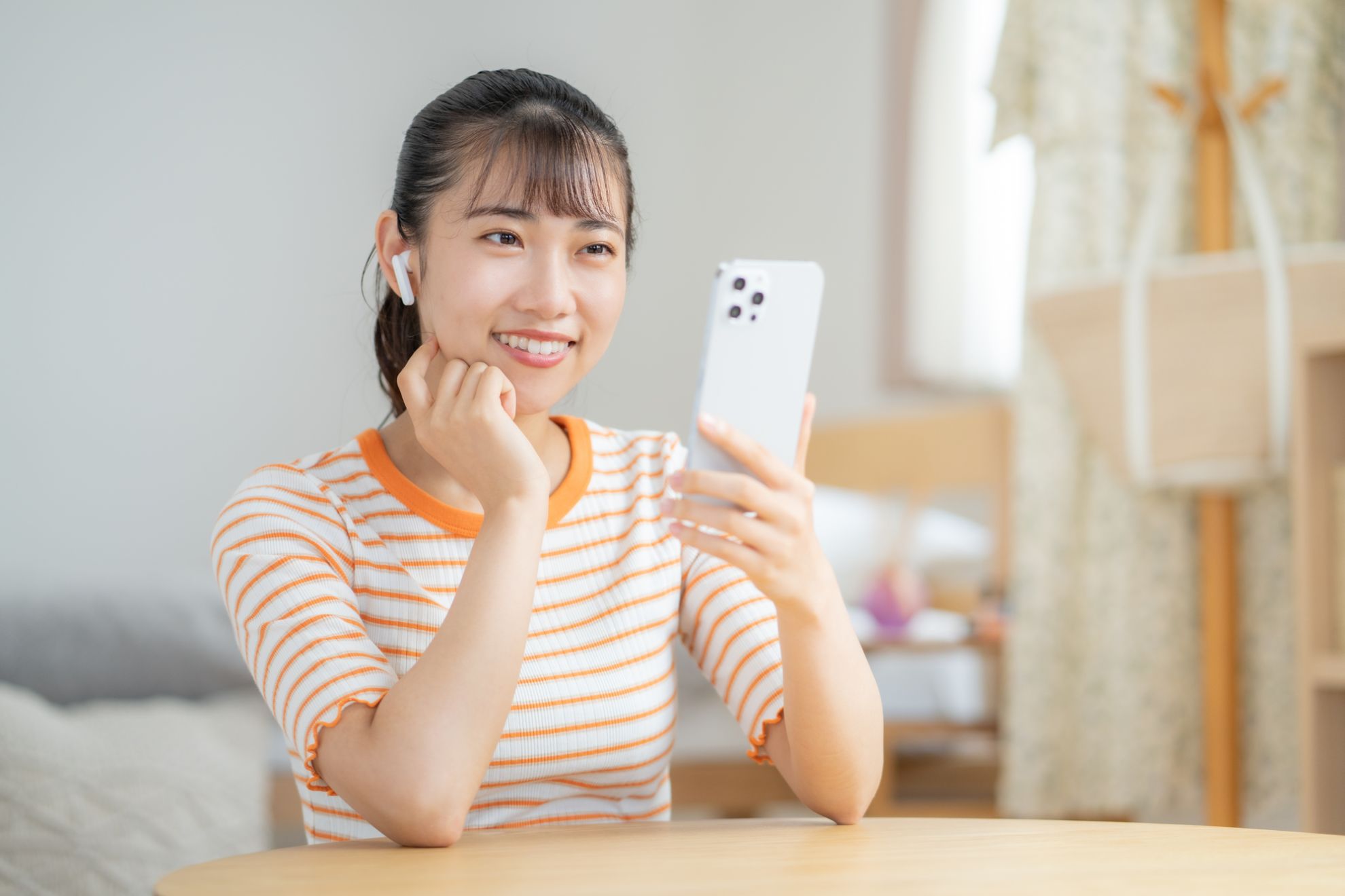 スマホでテレビを見る女性