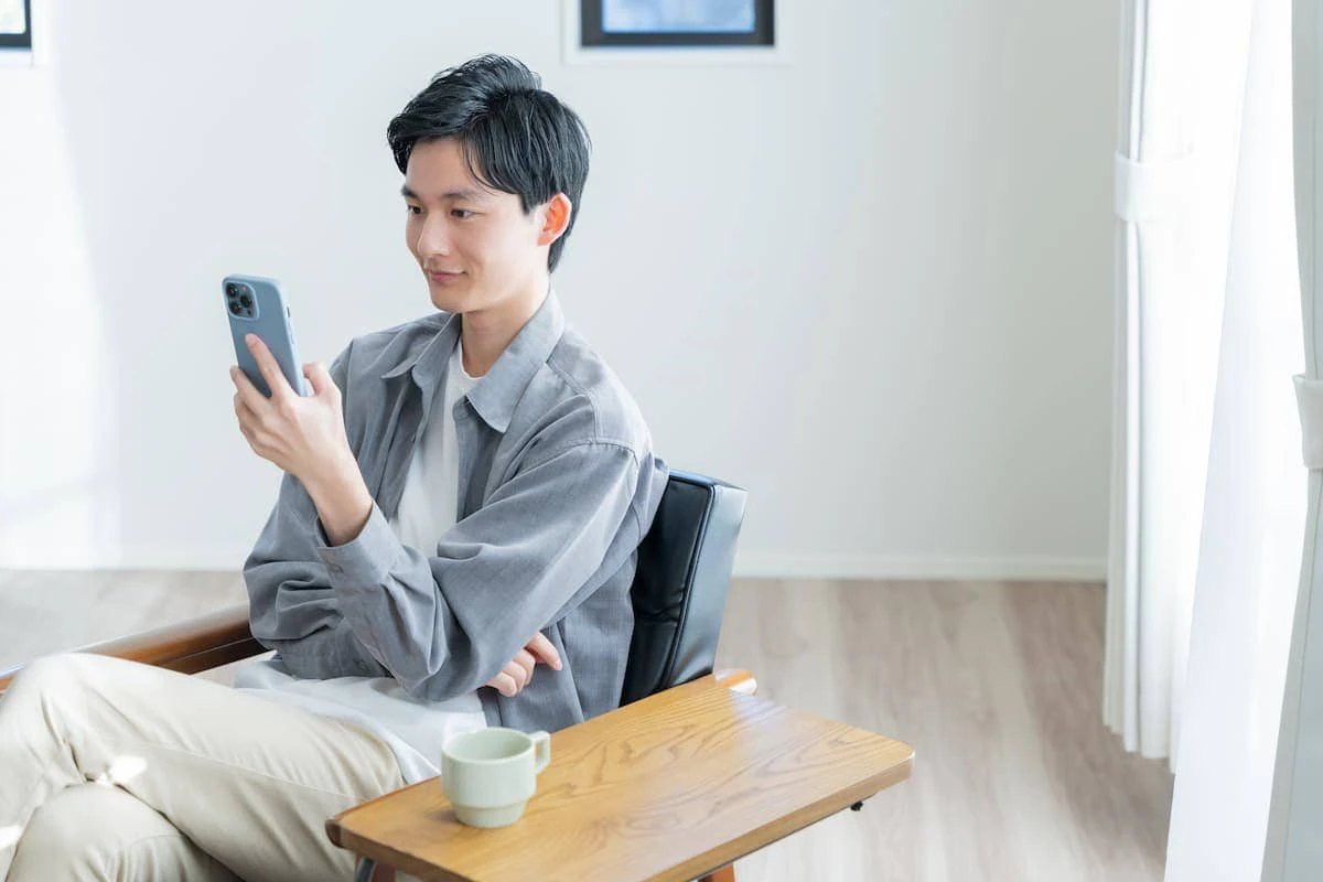 スマホを触る男性の写真