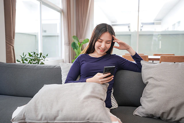 スマホを持ちPCを触る女性