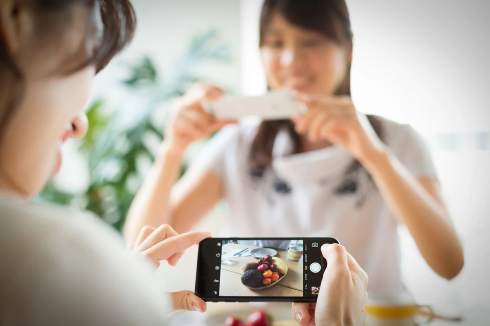 スマホで写真を撮る女性