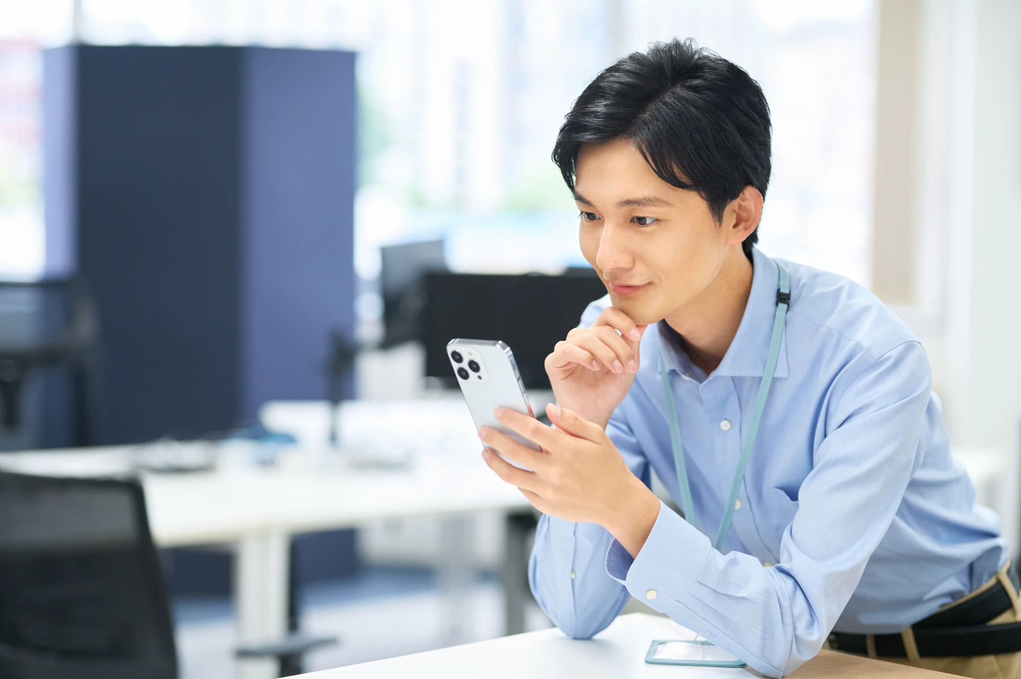 座ってスマホを見る男性