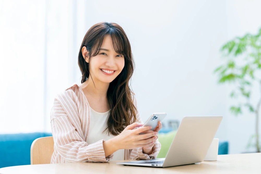 スマホとPCを開く女性