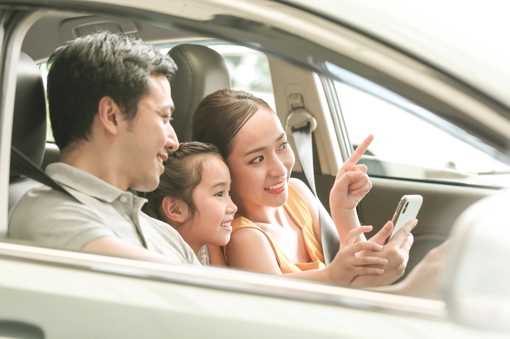 車内でスマホを見る家族