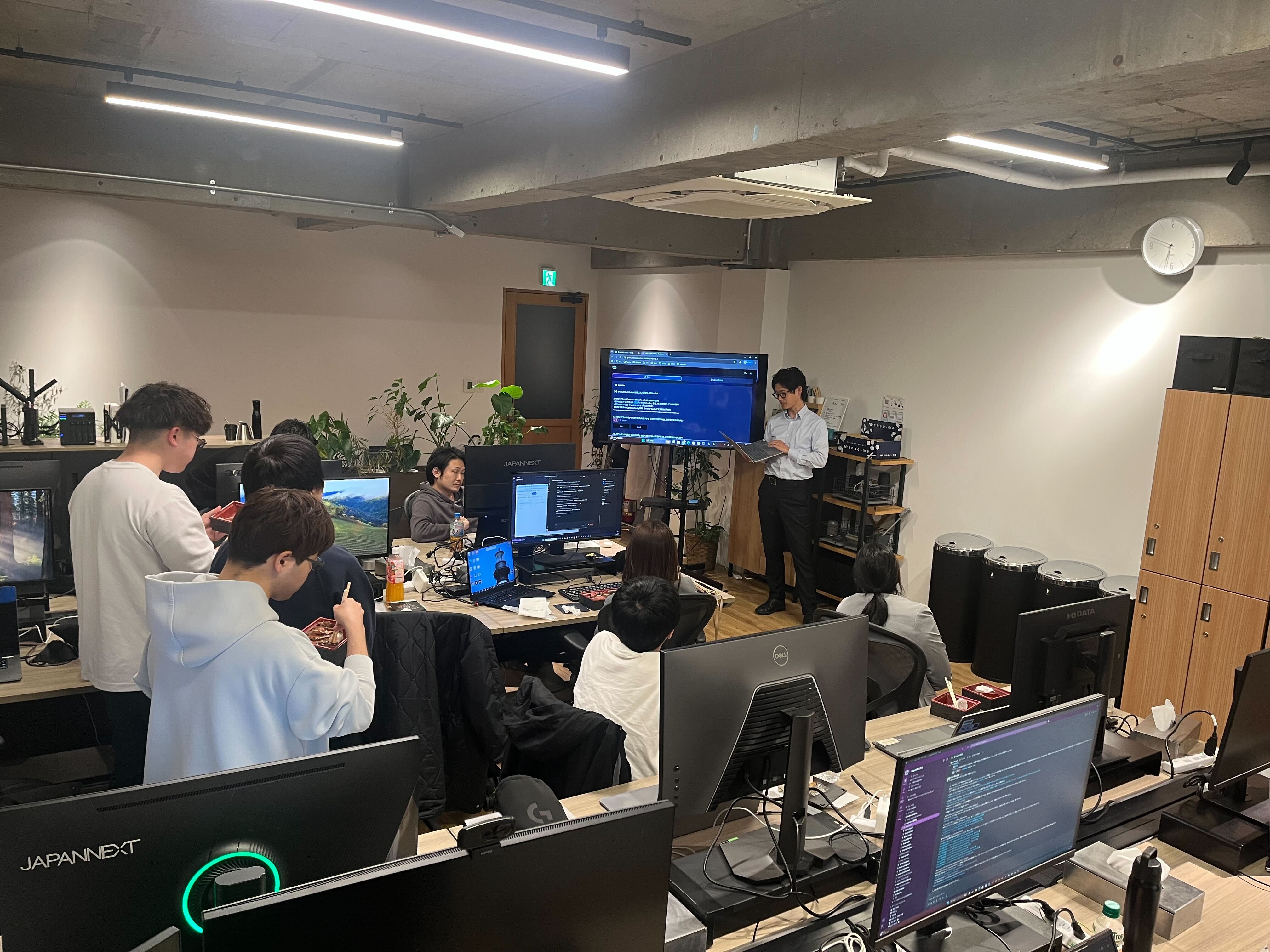 LT会の会場の様子。メンバー全員が集まり、大型ディスプレイを囲んで発表を聞いている