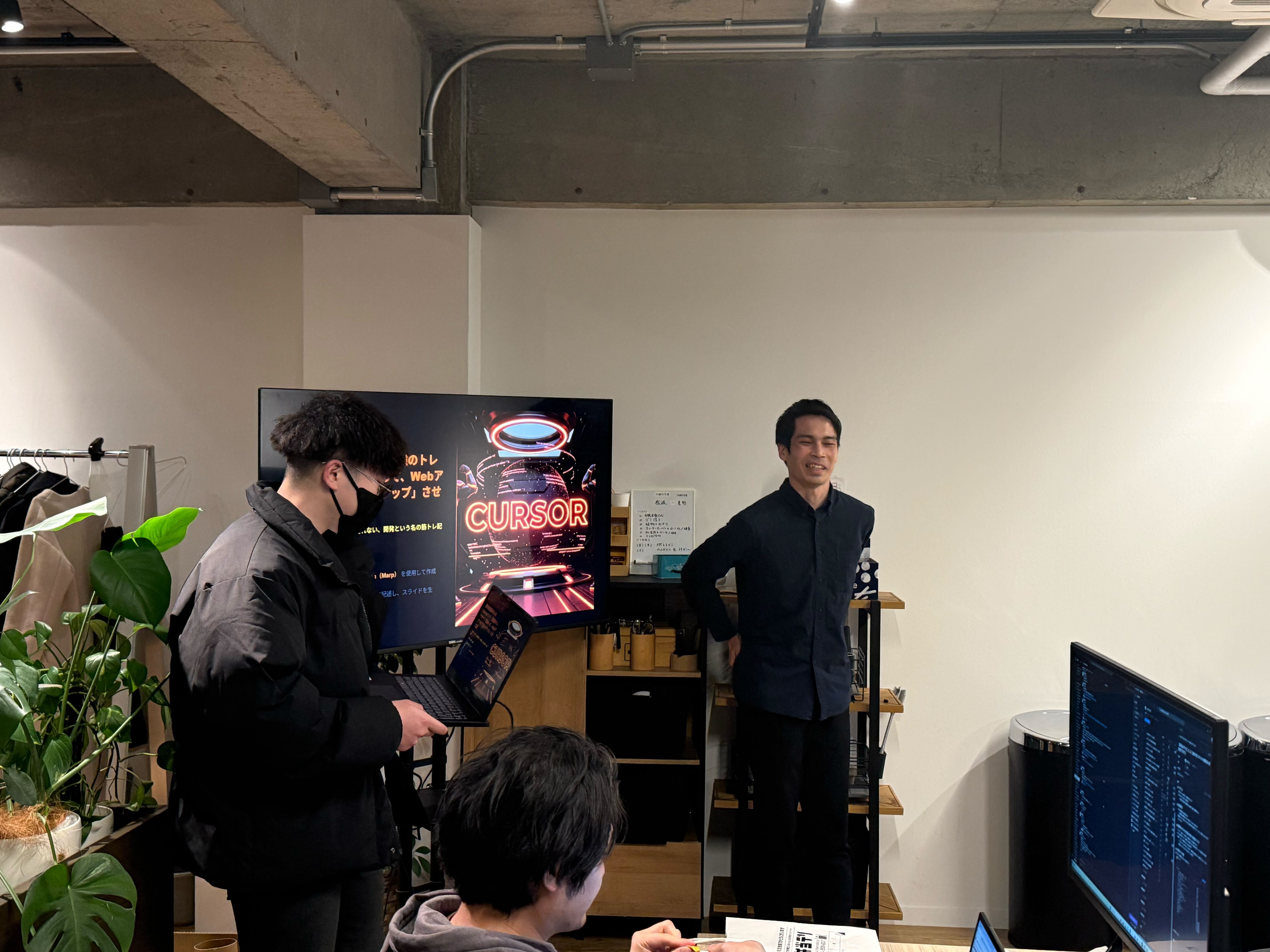 CURSORのスライドを前に新入社員2人が発表している様子