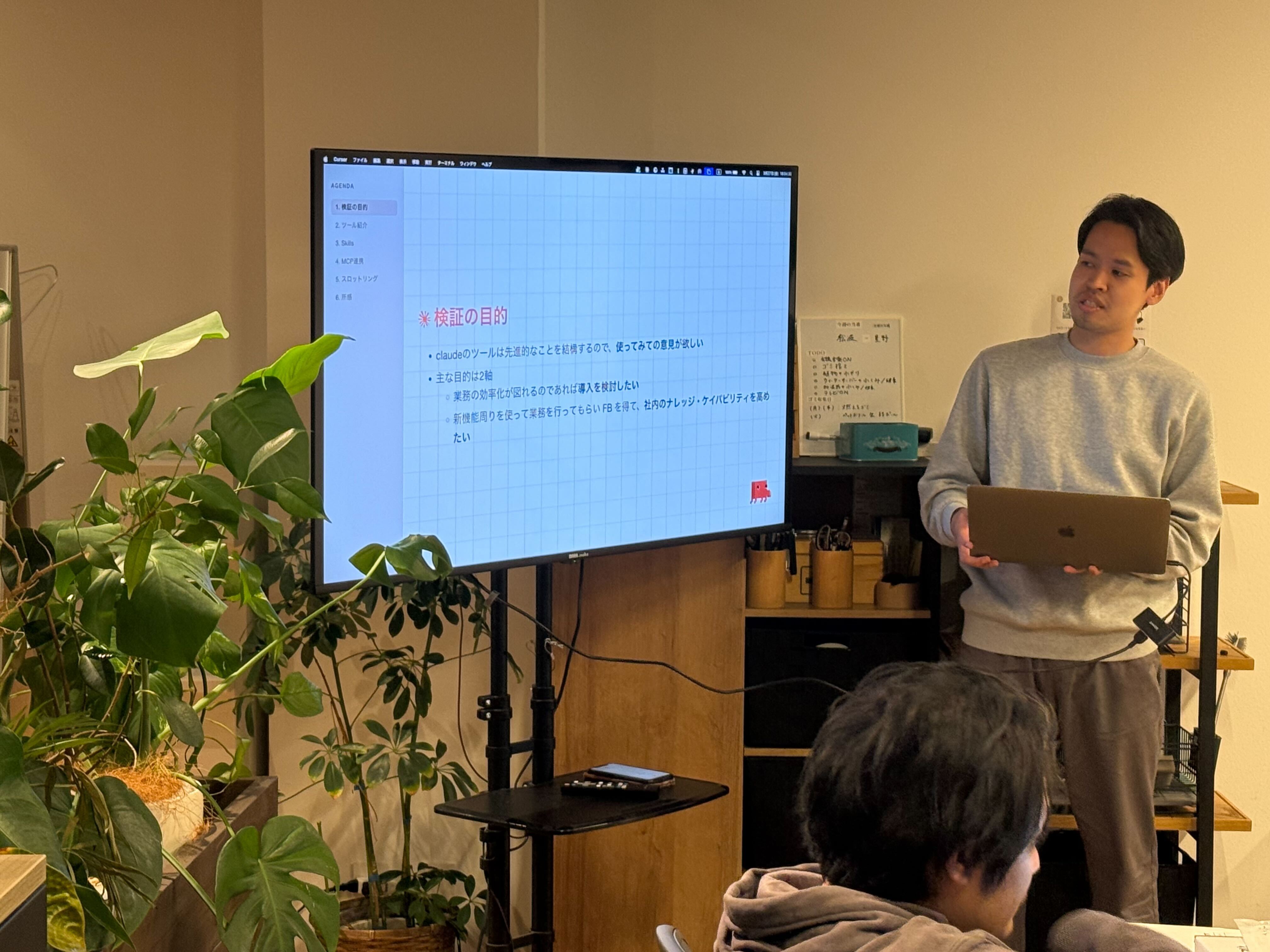 Claude Desktopの検証目的を説明するスライドを前に発表する様子