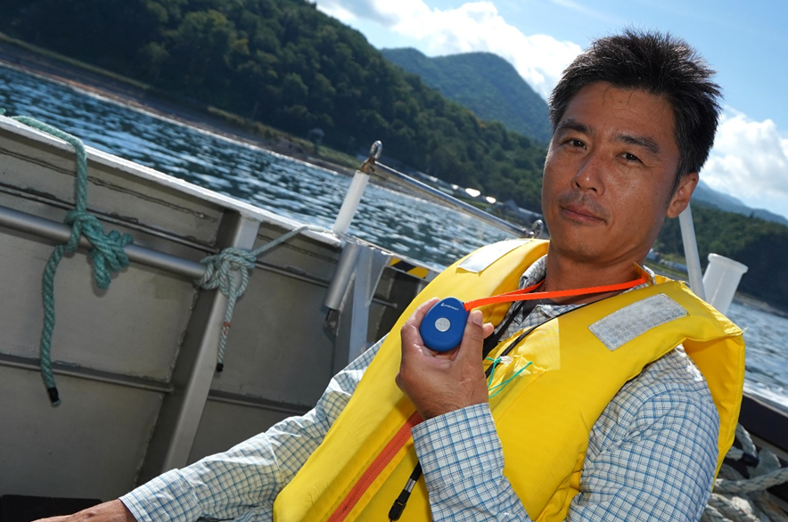 釣りドコ　ブログ　～海の安全対策を学びたい Vol.4～　海難救助サービスよびもり　　知床半島　ウトロ　ゴジラ岩観光　船上のごっとりくん　よびもりを握っている　写真