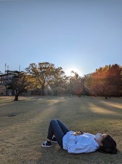 筆者がICUのキャンパスに寝転んでいる