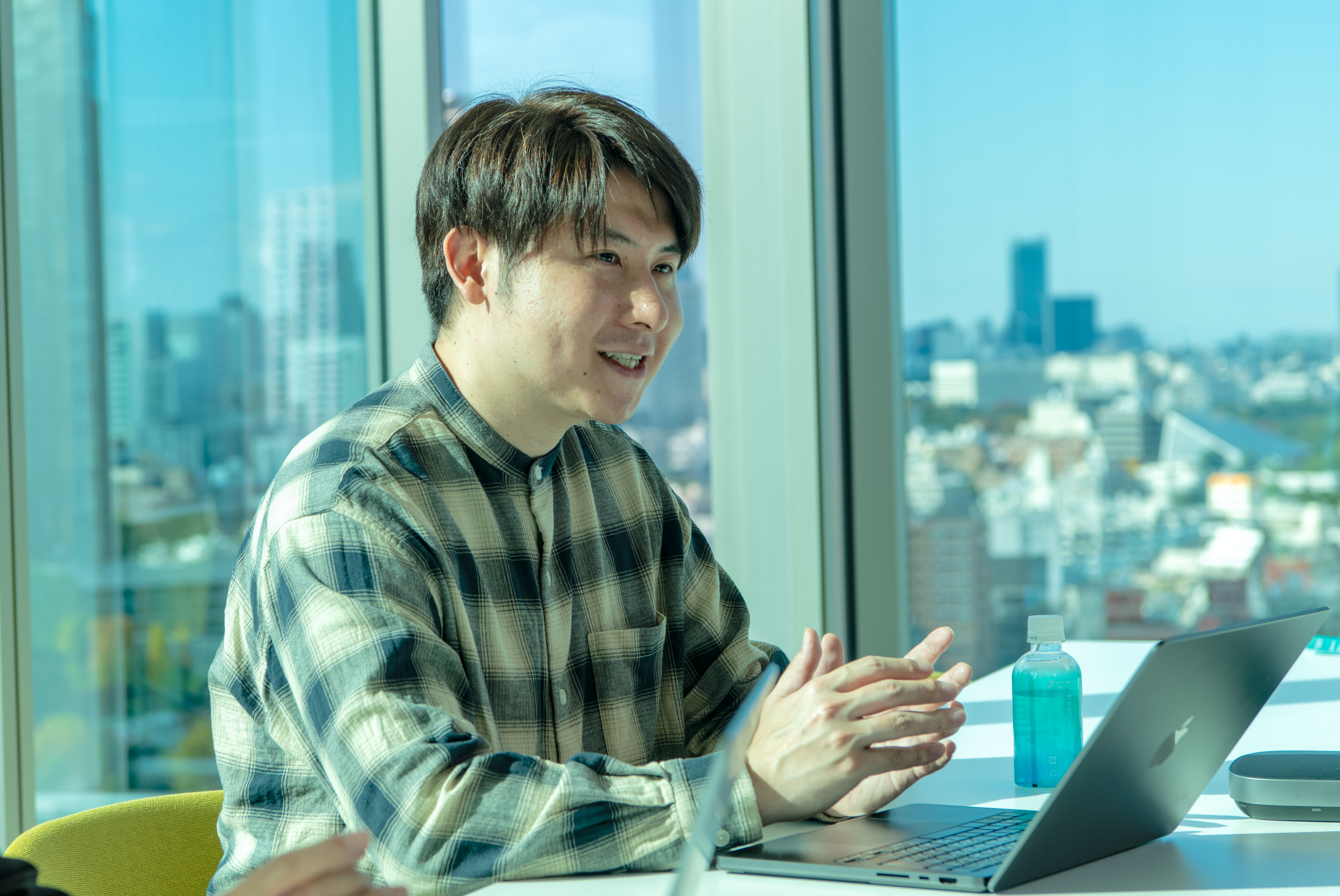 ノートパソコンを前に、開発のきっかけや思いを熱心に語る開発者の谷さん