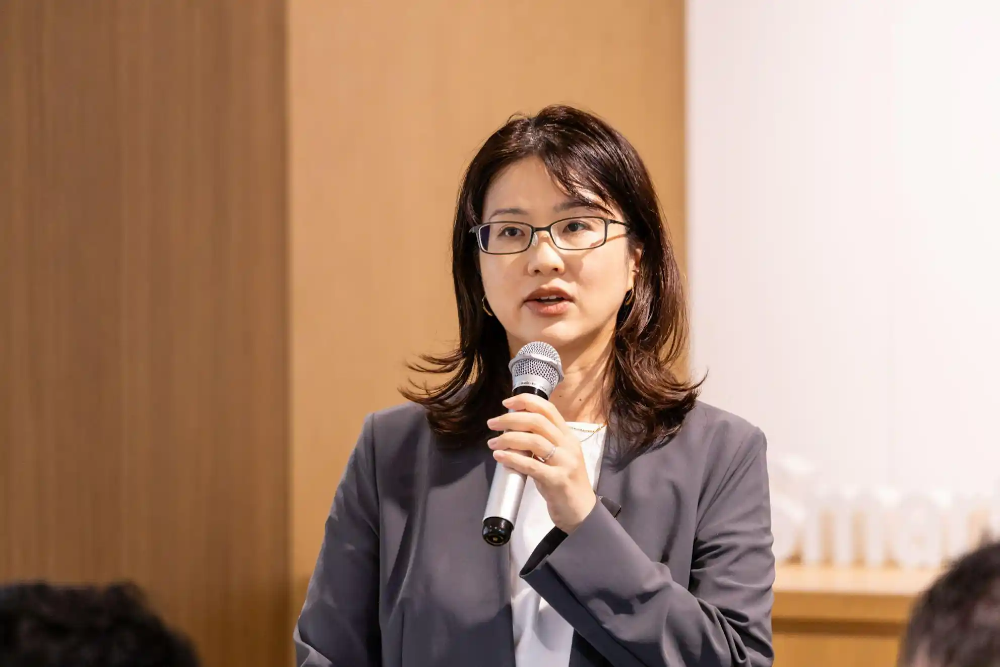 イベントに登壇し、マイクを握って説明をする眼鏡をかけた松栄さん