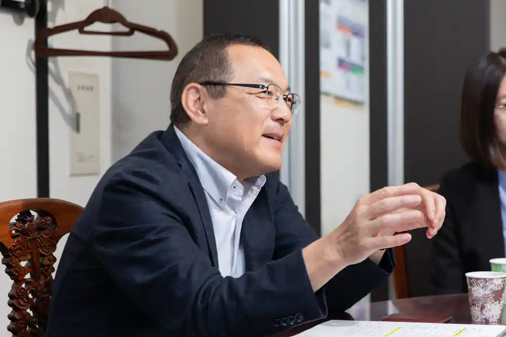 手振りをつけながら説明をしている男性の写真。