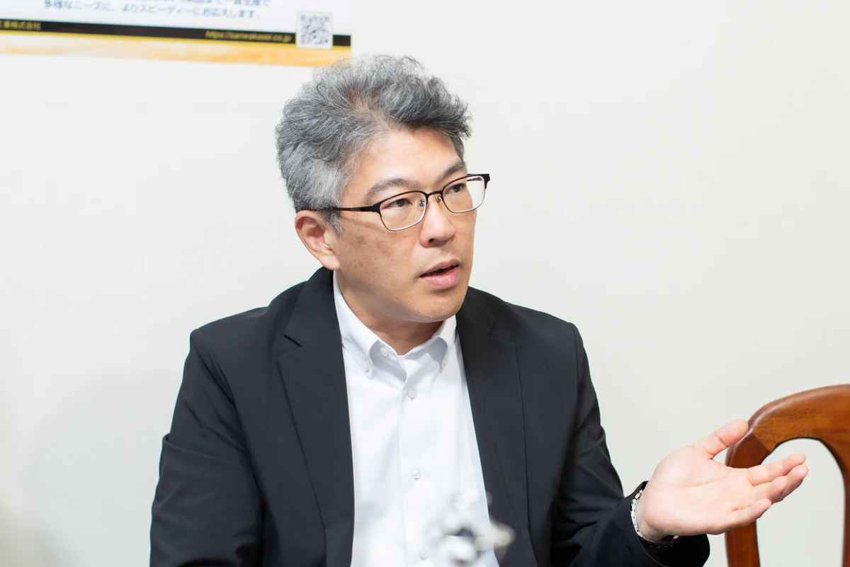 手振りをつけながら説明をしている男性の写真。