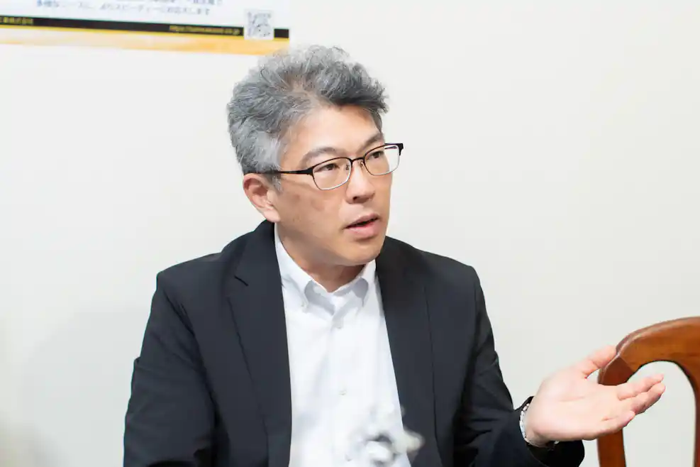 手振りをつけながら説明をしている男性の写真。