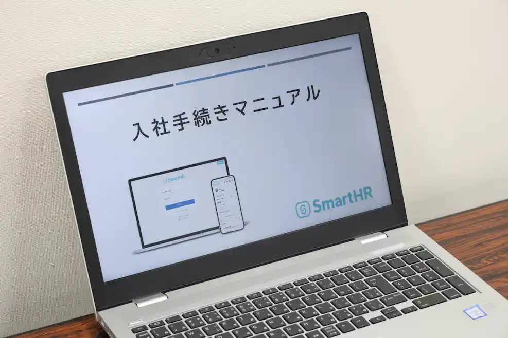 SmartHR入社手続きマニュアルという画面が写ったパソコン