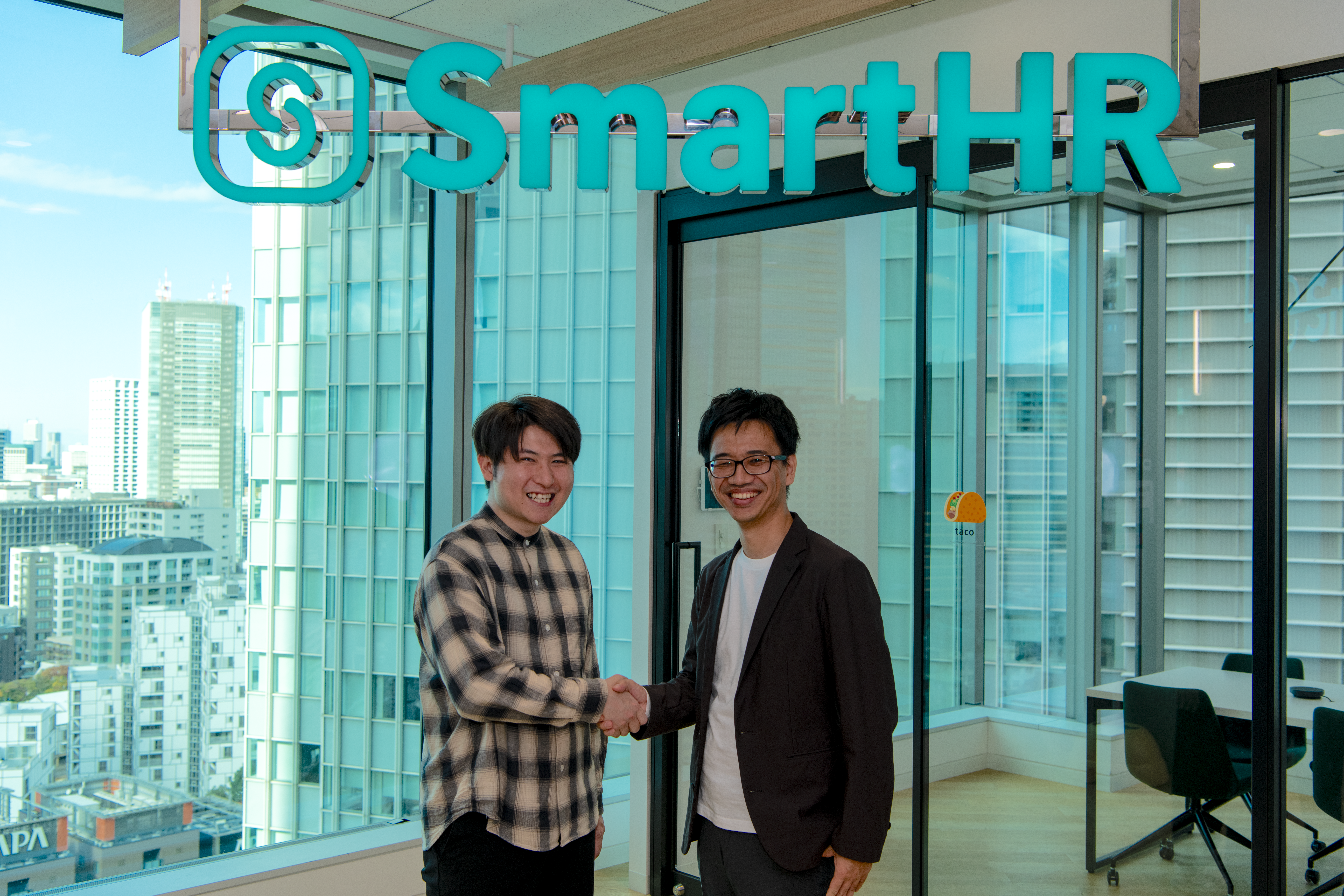笑顔で握手する、開発者の谷さん（左）とSmartHRの小山（右）