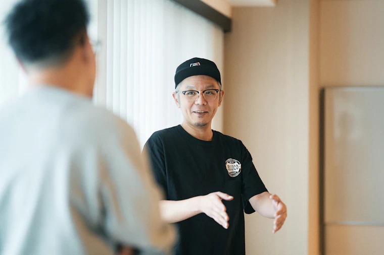 大きい窓の前で阪口と話す堀江