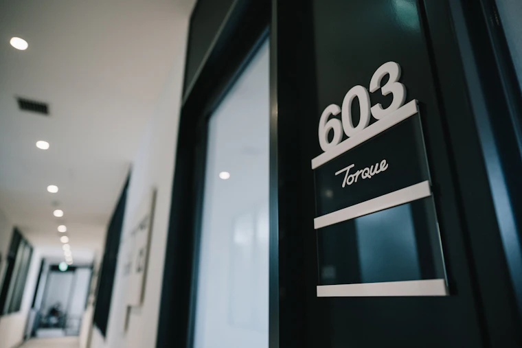 603という部屋番号と会社ロゴが飾られたオフィス入り口。