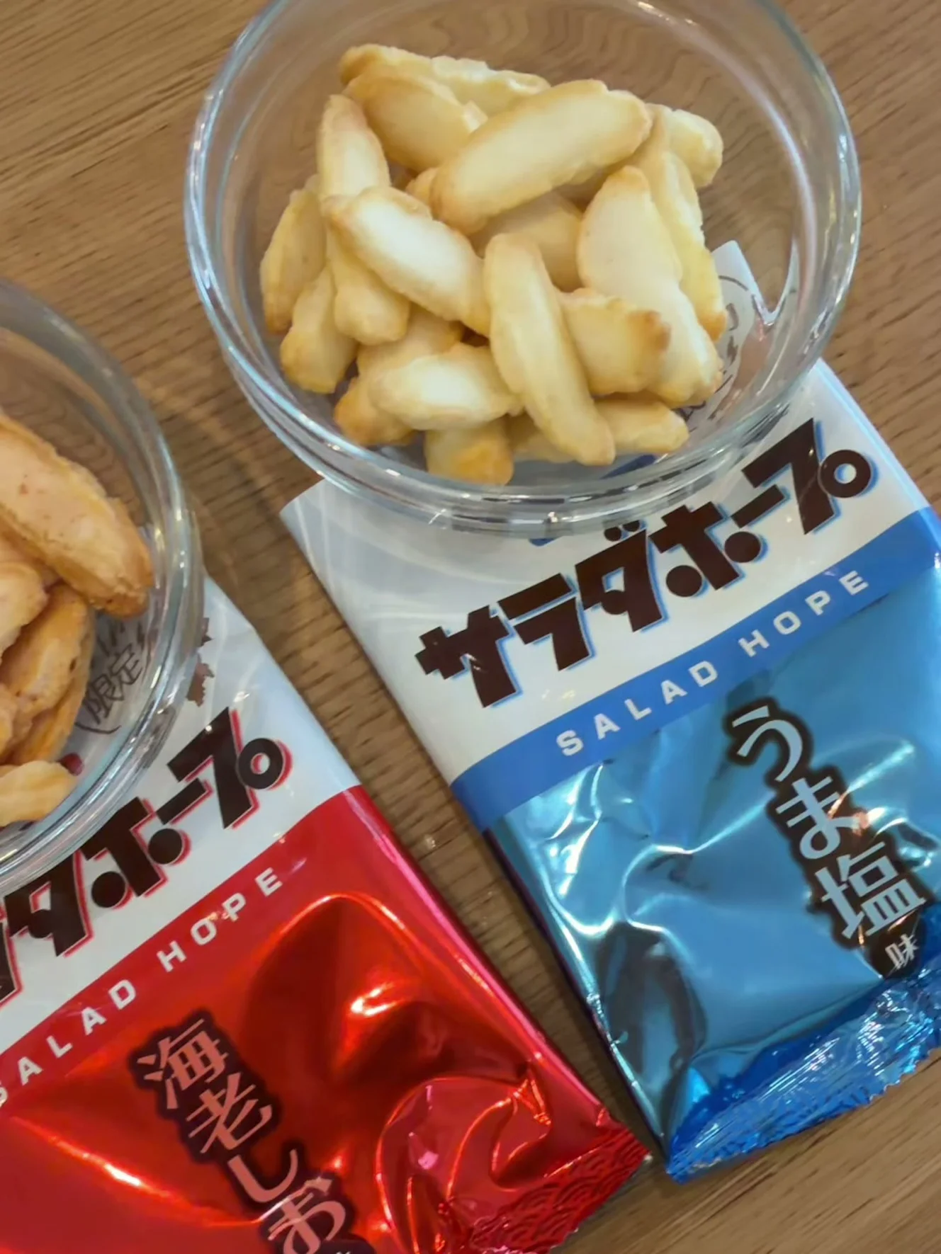 ガラスの器に出したうま塩味のあられ。青いうま塩味の小袋の上に器が乗っている