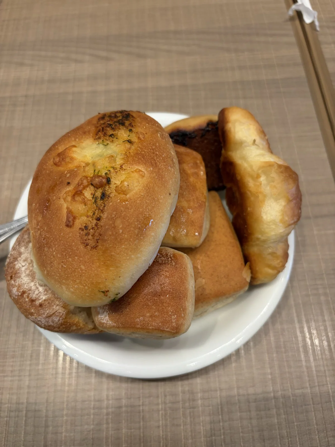 食べ放題から取ってきたパンを盛った白い皿