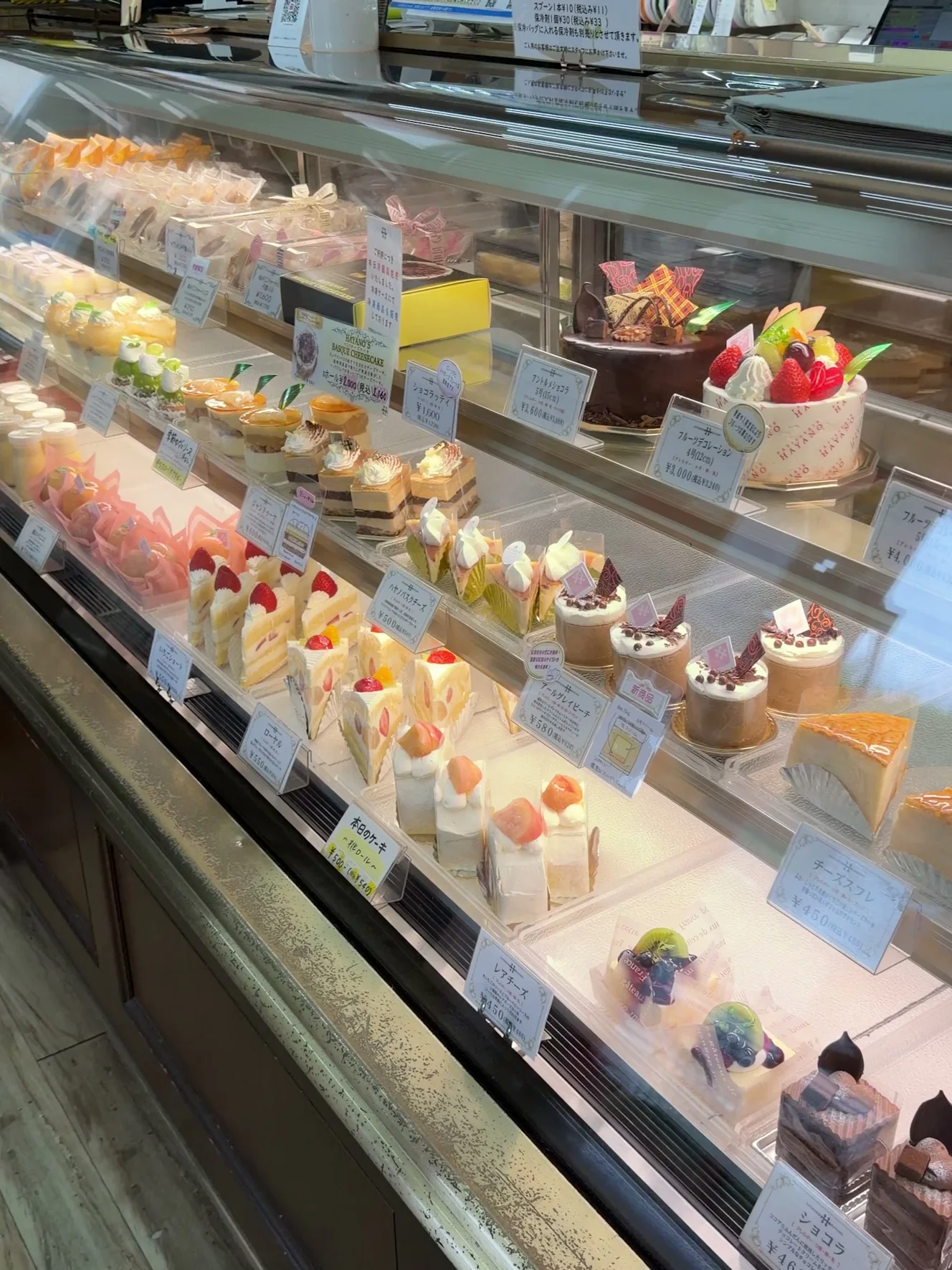 生ケーキとホールケーキ、焼き菓子が3段に並ぶ1NO1店のショーケース