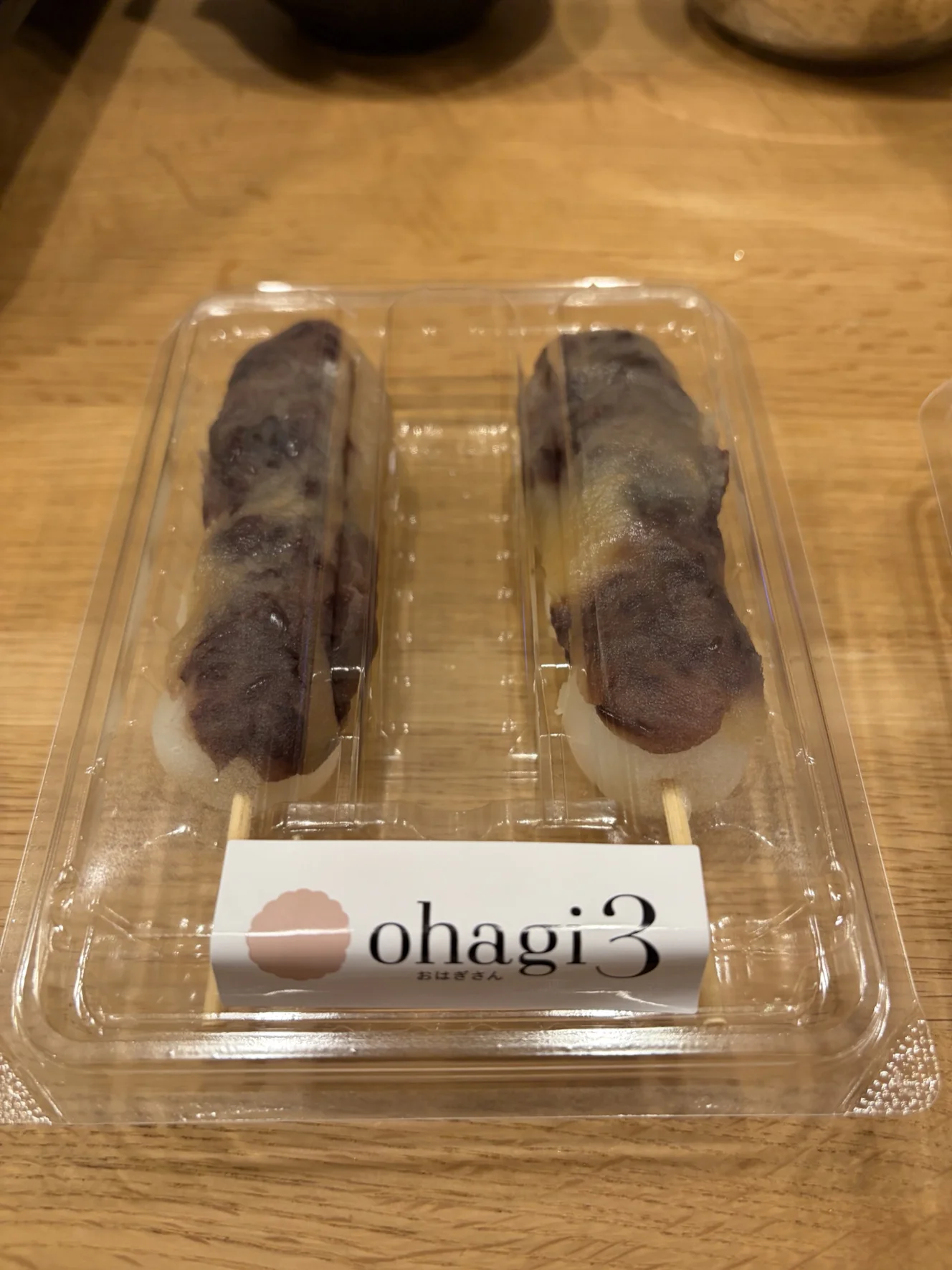 フタ付きのパックに入った花塩団子。白い団子にあんこが細長く乗っている