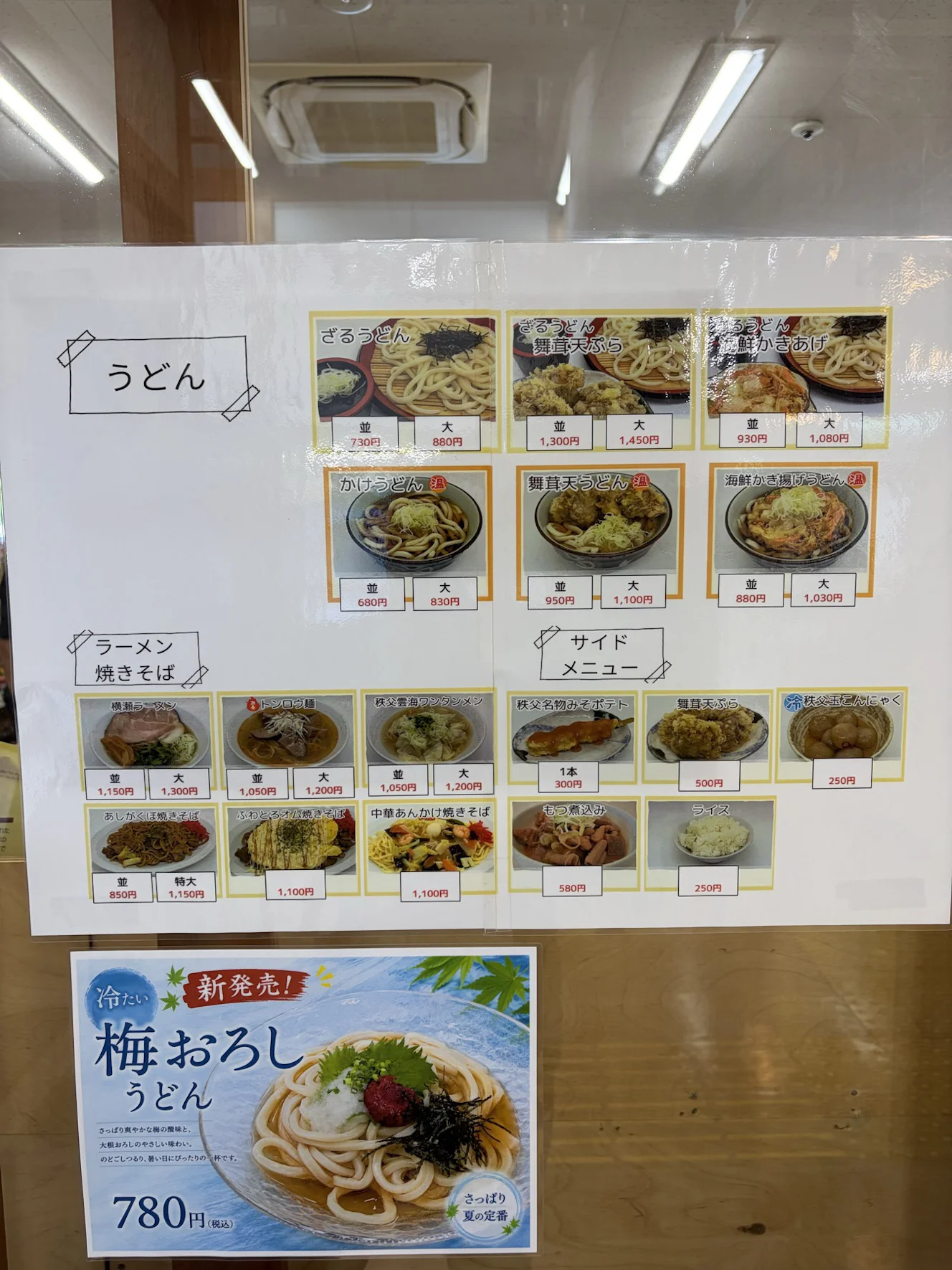 うどん・ラーメン・焼きそばのメニュー表と梅おろしうどん780円の掲示