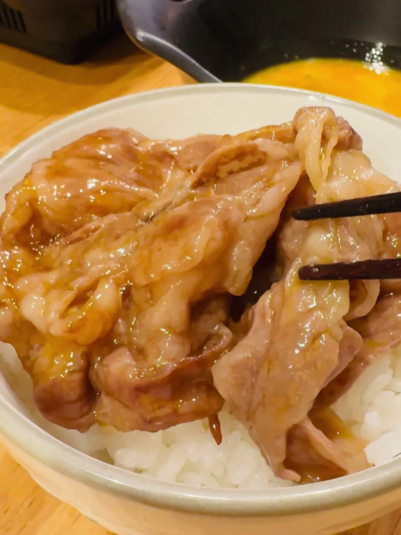 溶き卵をまとったすき焼きの肉を、白ごはんに乗せたところ