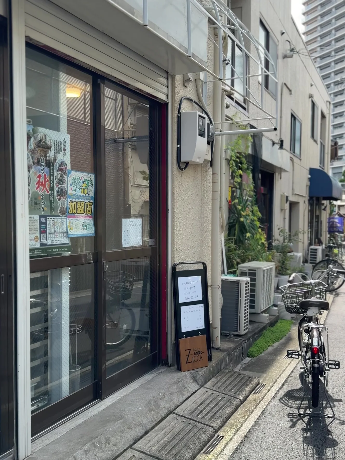 Bakery ZICCAの外観。ガラス戸の前に小さな立て看板があり、通りに自転車が停まっている