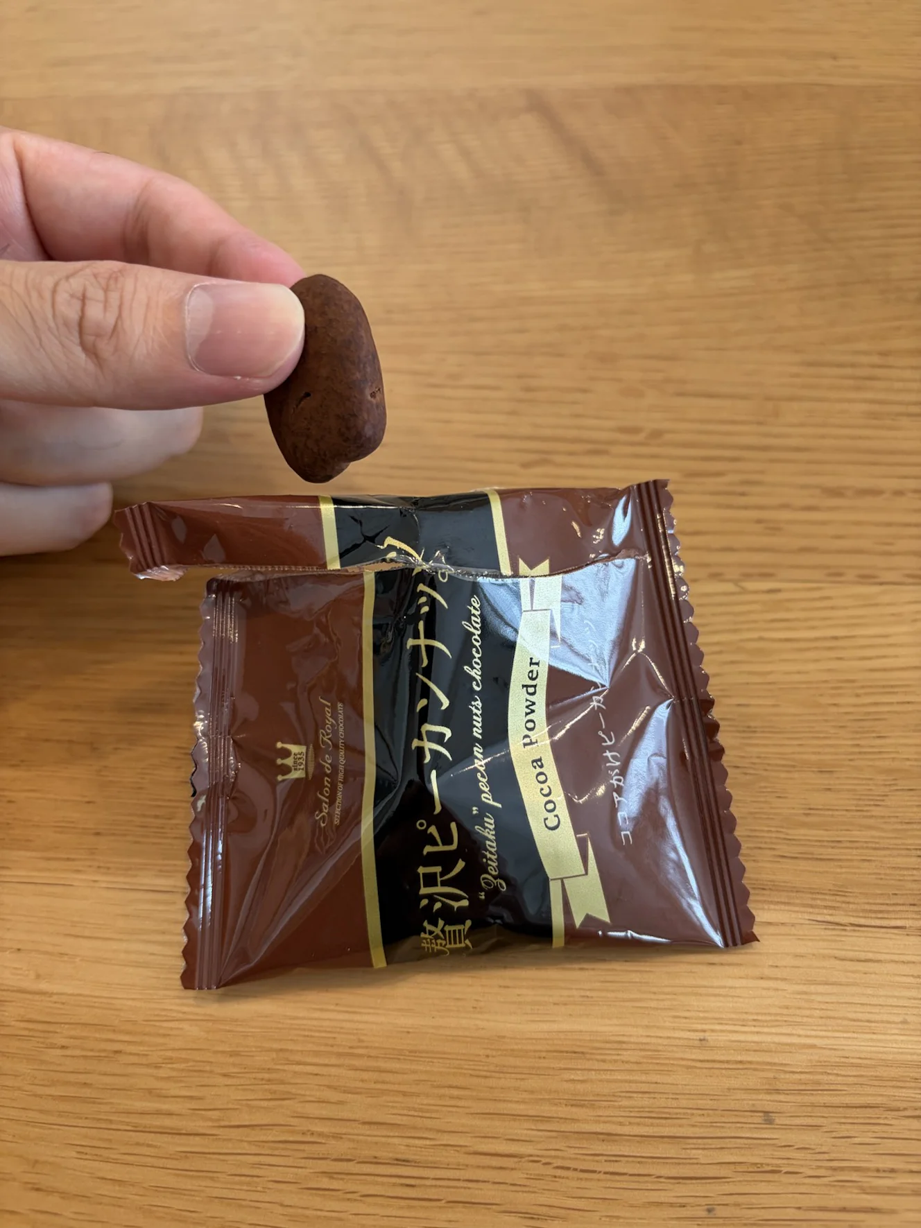ココアがけピーカンナッツ。濃い茶色で、細長い楕円形