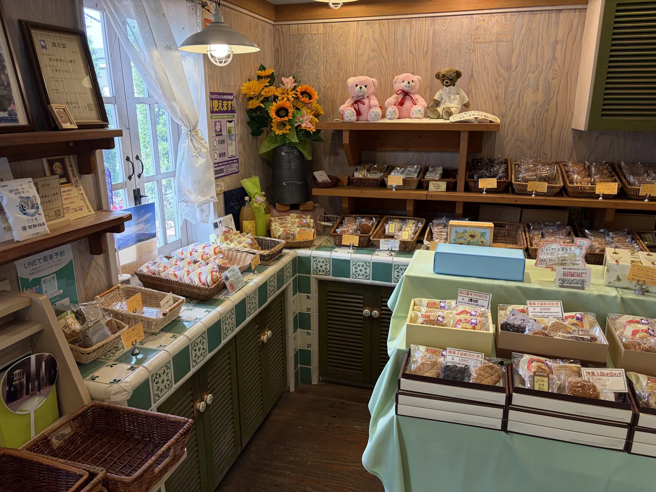 緑のタイルカウンターに焼き菓子のカゴが並ぶお菓子の家SWANの店内