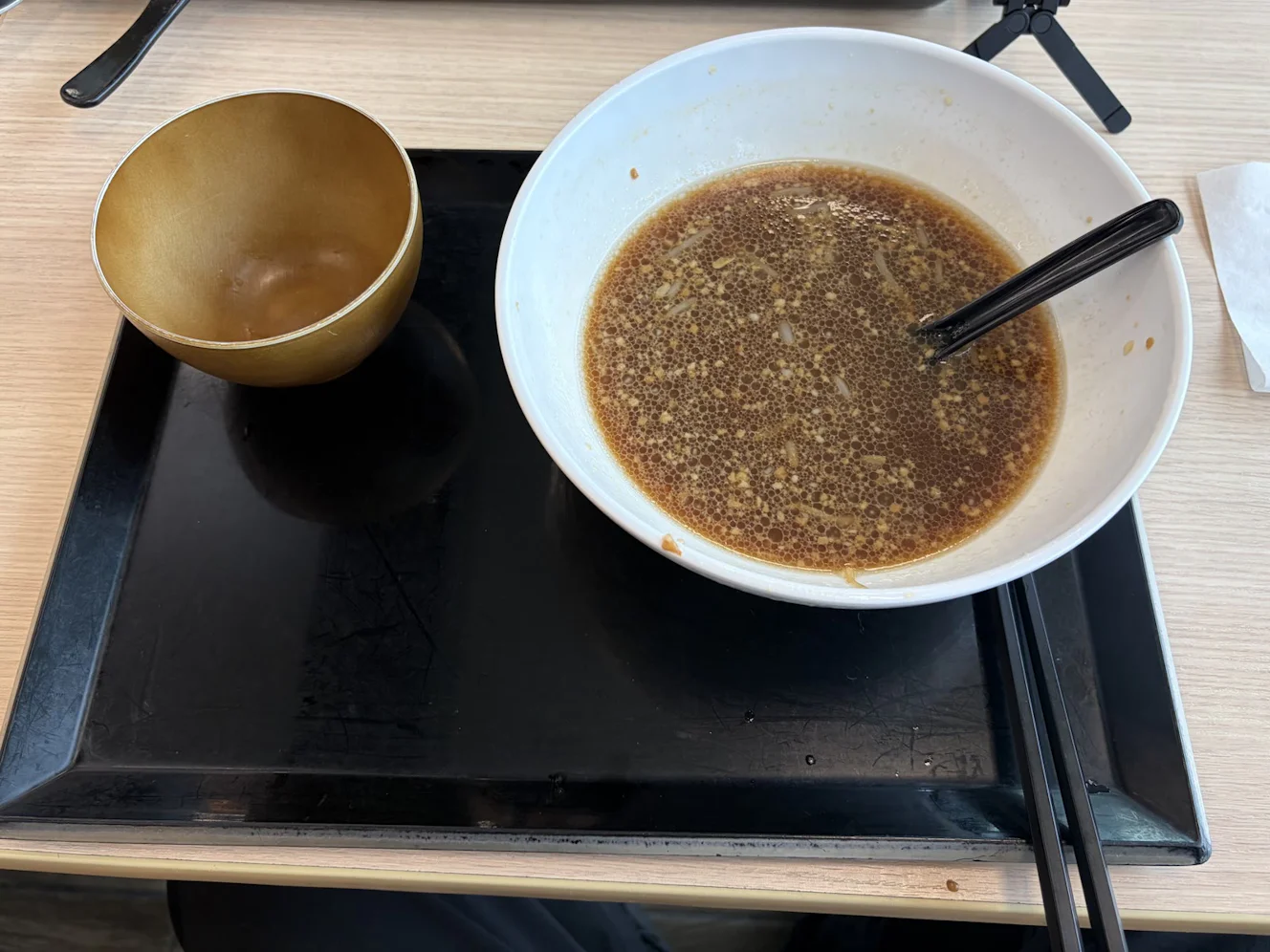 食後の丼。麺と具は無くなり、醤油色のスープが残っている。隣のごはんの椀は空になっている