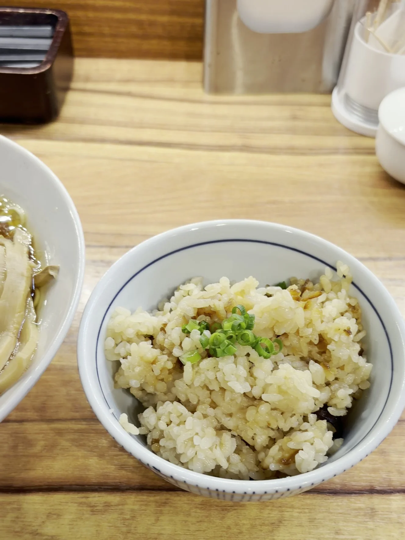 日替わりご飯300円。干貝柱とシイタケの炊き込みご飯に青ねぎが載っている