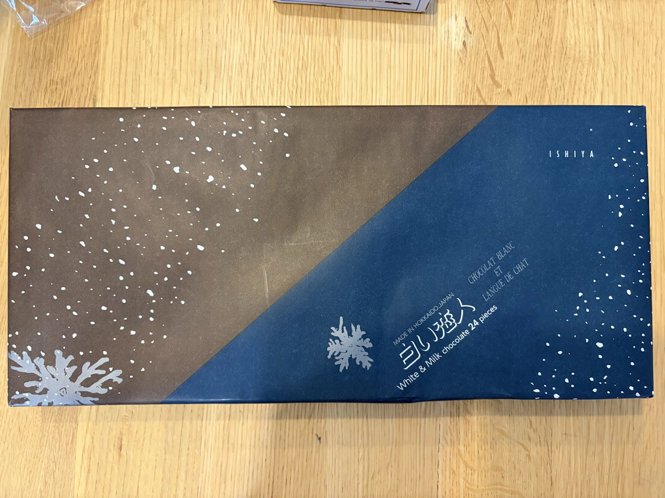白い恋人24枚入の外装スリーブ。紺と茶の斜め分割にWhite & Milk chocolate 24 piecesの表記