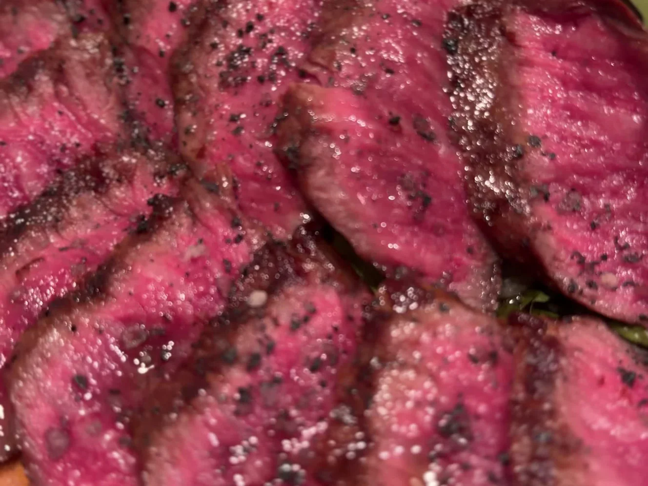 黒こしょうをふって薄く切り分けられた熟成肉のアップ