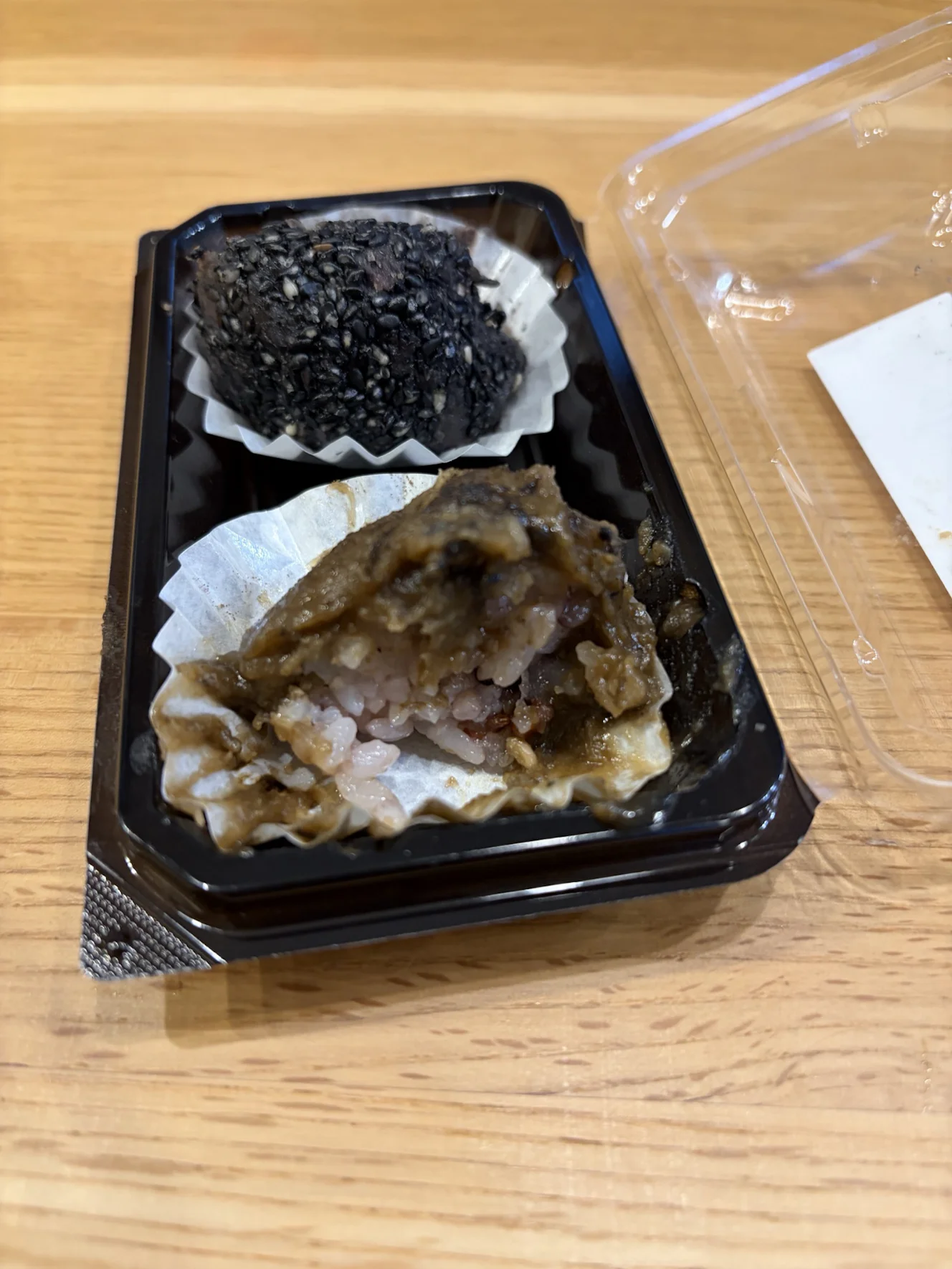 半分に割ったほうじ茶のおはぎの断面。手前がほうじ茶で、奥に黒ゴマが見える