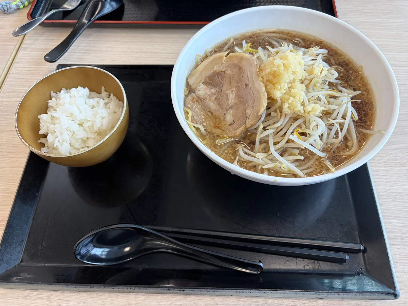トレーに載った酒々郎ラーメンとごはん。丼にはもやし、刻みにんにく、チャーシュー1枚が載っている