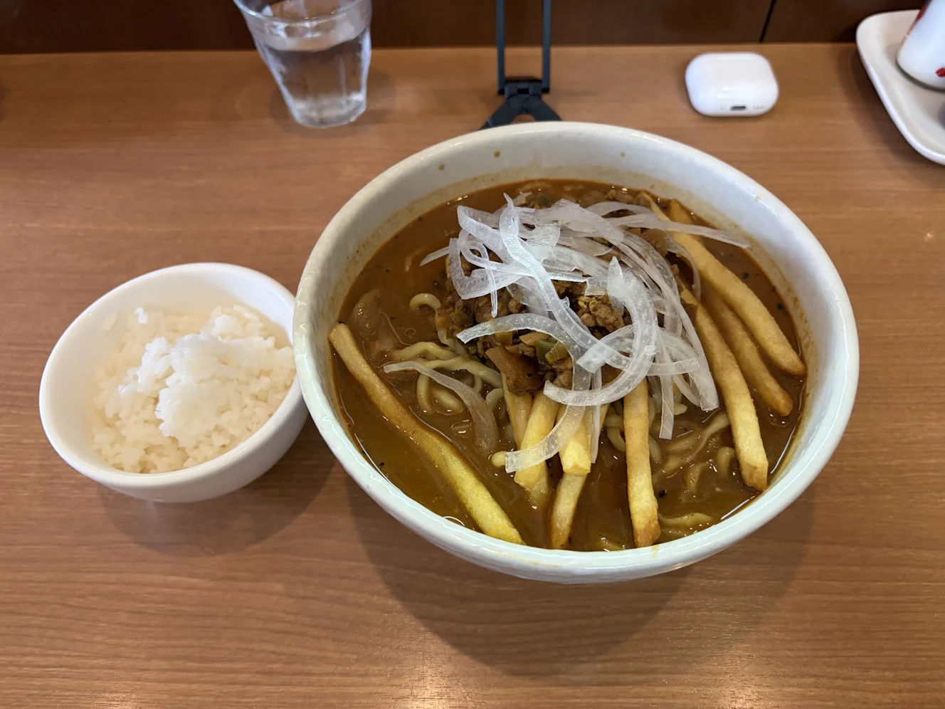 提供時のガーリィ担々麺（麺大盛り）と半ライス。カレー色のスープに太めの麺と棒状のフライドポテトが入っている