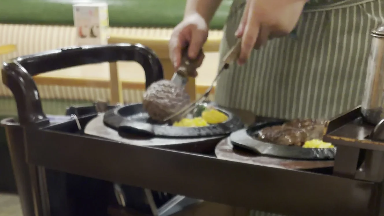 ワゴンの上で半分にカットされる爆弾ハンバーグ