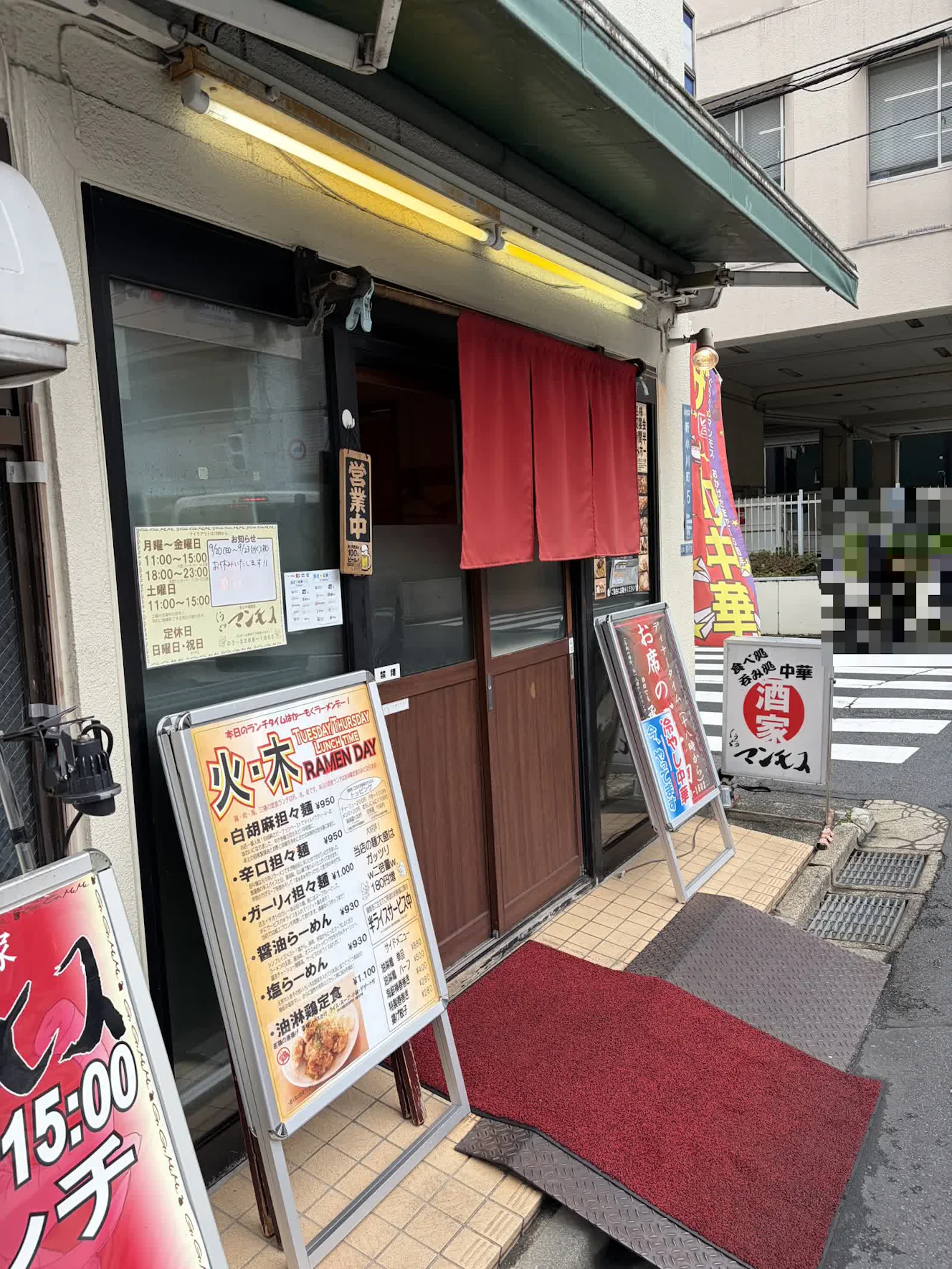 赤い暖簾がかかった店先。立て看板にランチメニューが出ている