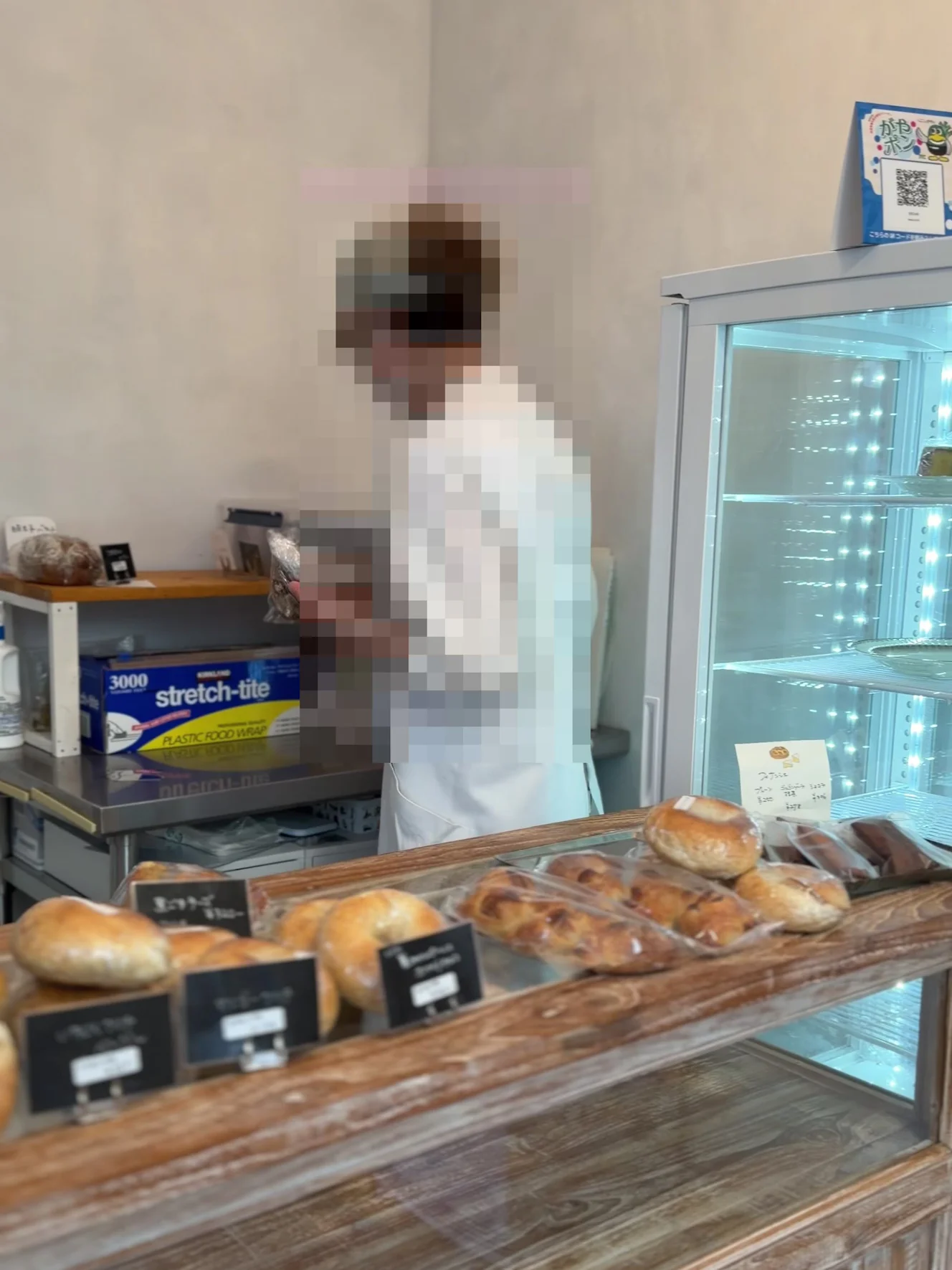 店内。木のカウンターにパンが並び、奥に冷蔵ショーケースがある