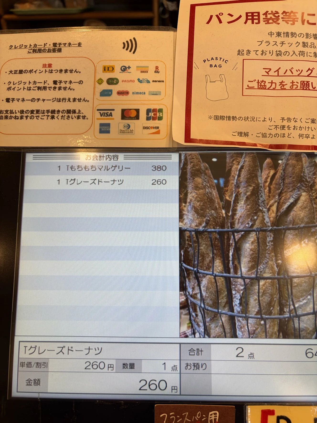 レジ横に貼られた決済手段の案内。クレジットカードや交通系ICを含む多数の電子マネーのロゴが並ぶ