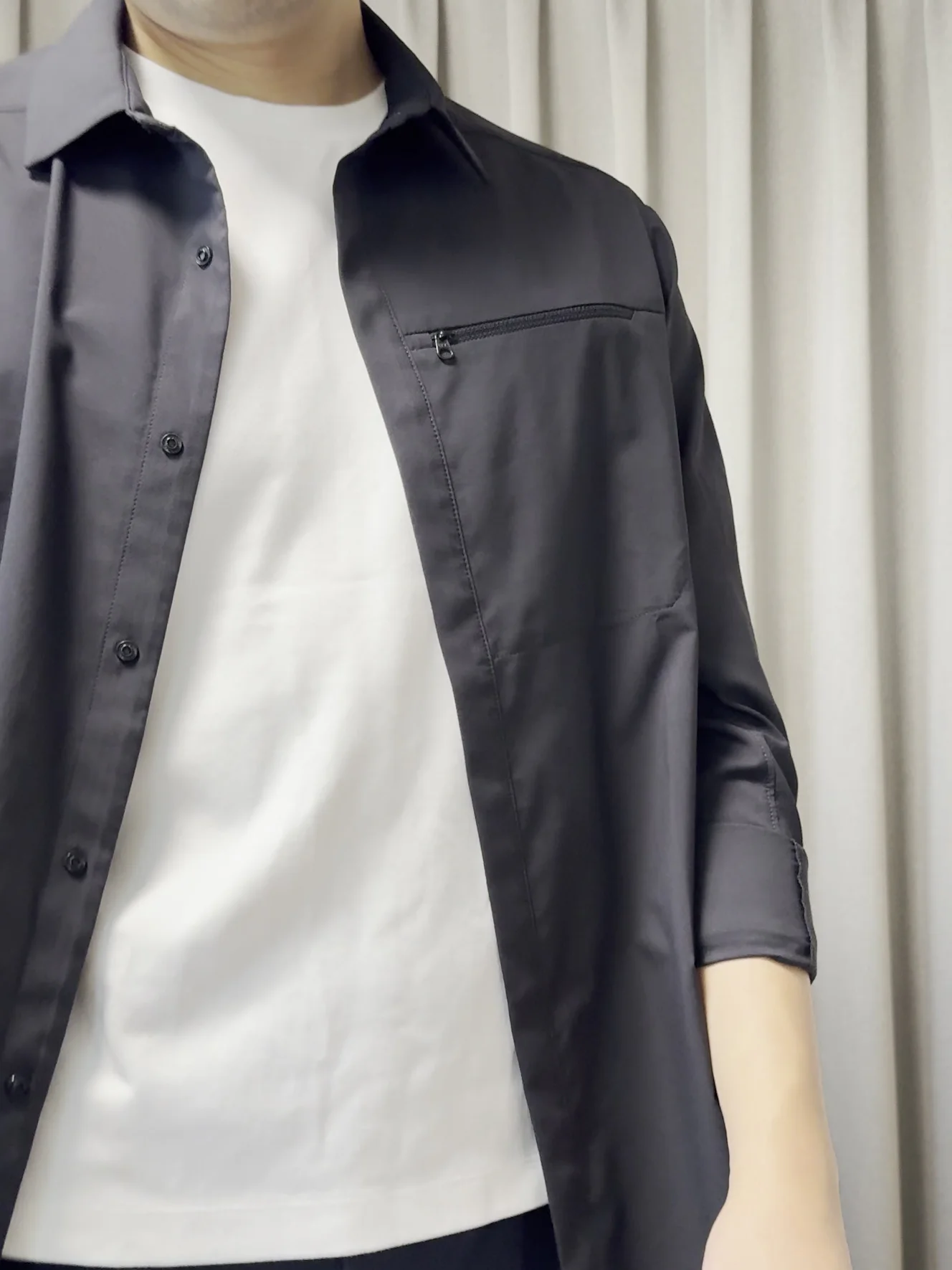 胸元の接写。襟、前立てに並んだスナップ、ジップ付きの胸ポケット、インナーの白いTシャツ