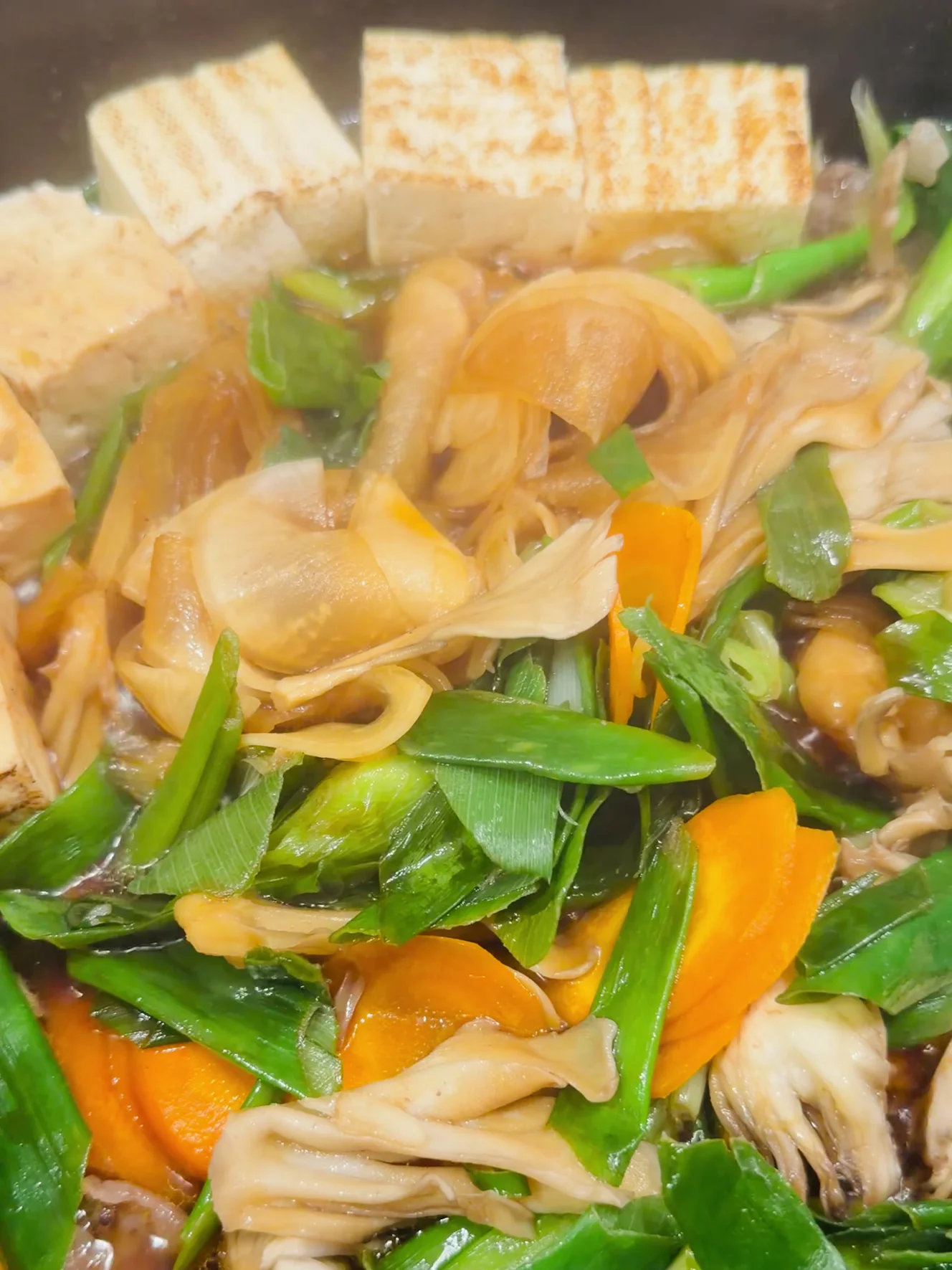 割り下で煮えてきた具材。焼き豆腐、九条ねぎ、まいたけ、にんじん、薄切りの大根
