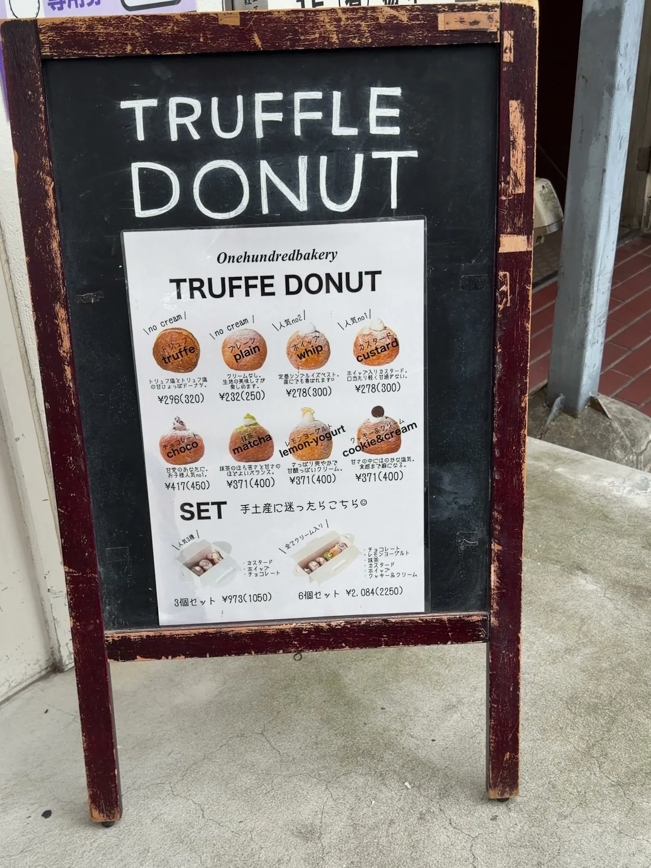 TRUFFLE DONUTの立て看板。8種類のドーナツの名前と価格、セットの案内が並んでいる