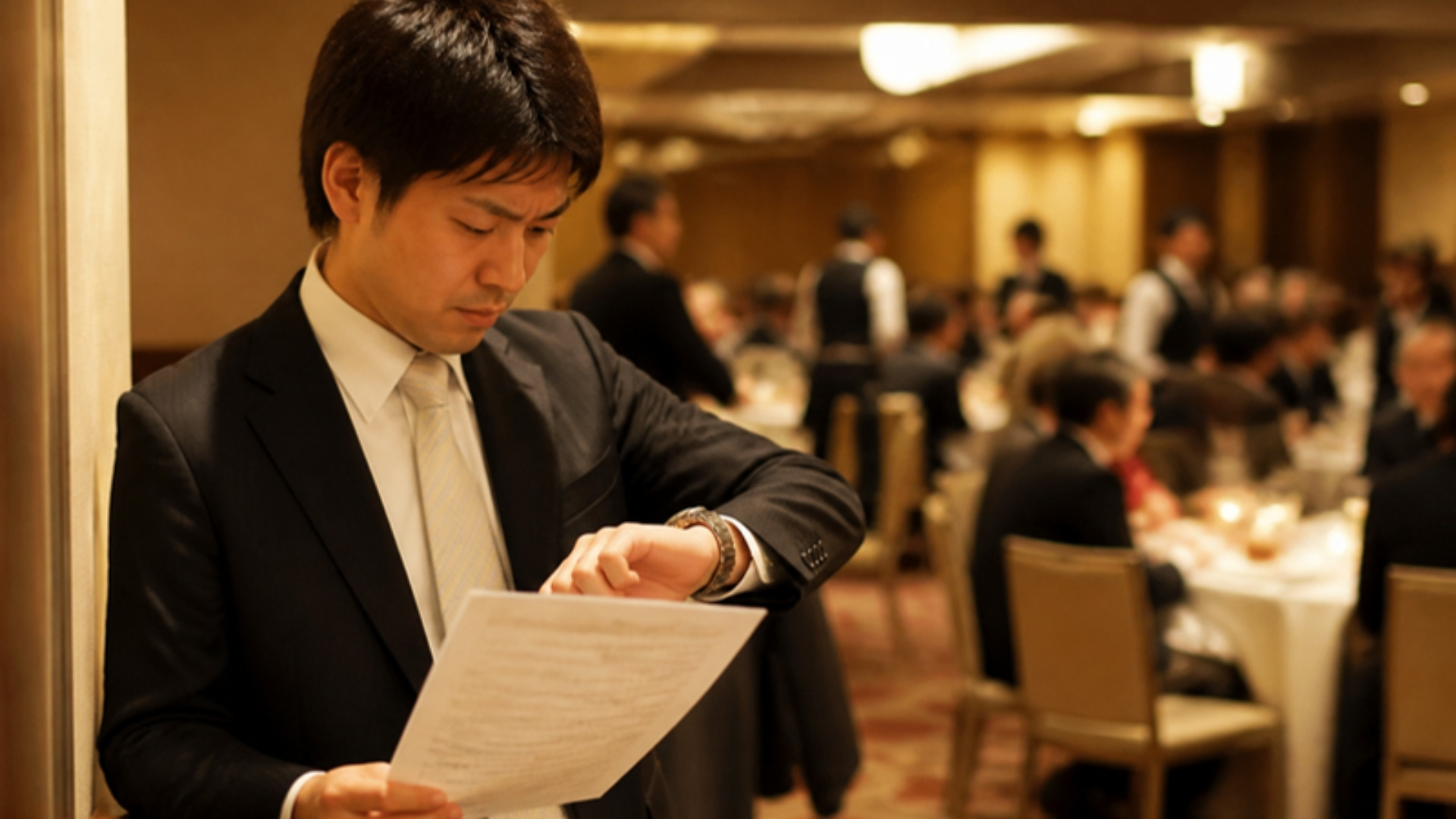 進行表で時間を確認する納会の幹事
