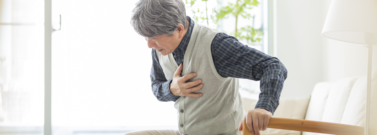 胸を手で押さえてつらそうにする高齢男性