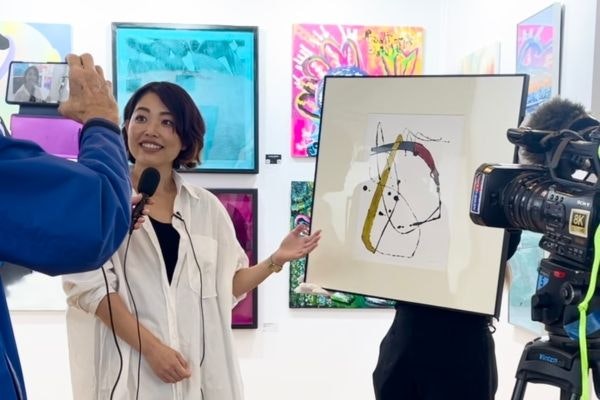  ルーブル美術館のアートイベントで作品をメディアに紹介するEMIさん