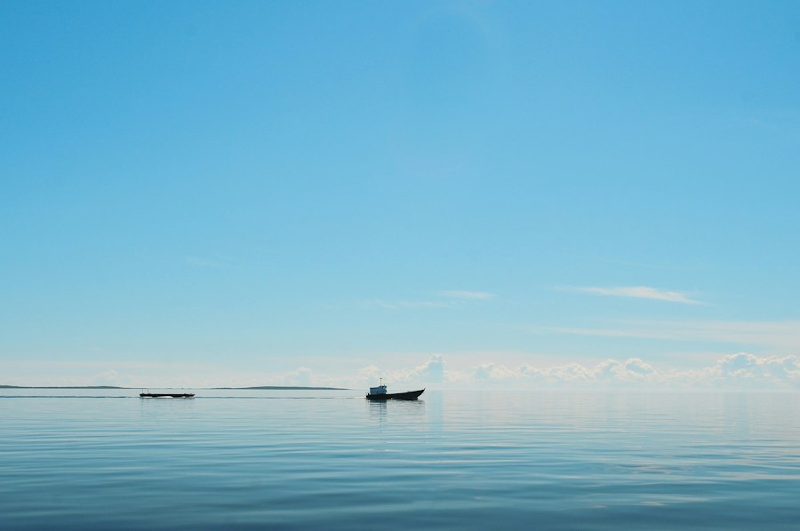 朝焼けの海に浮かぶ小舟のシルエット