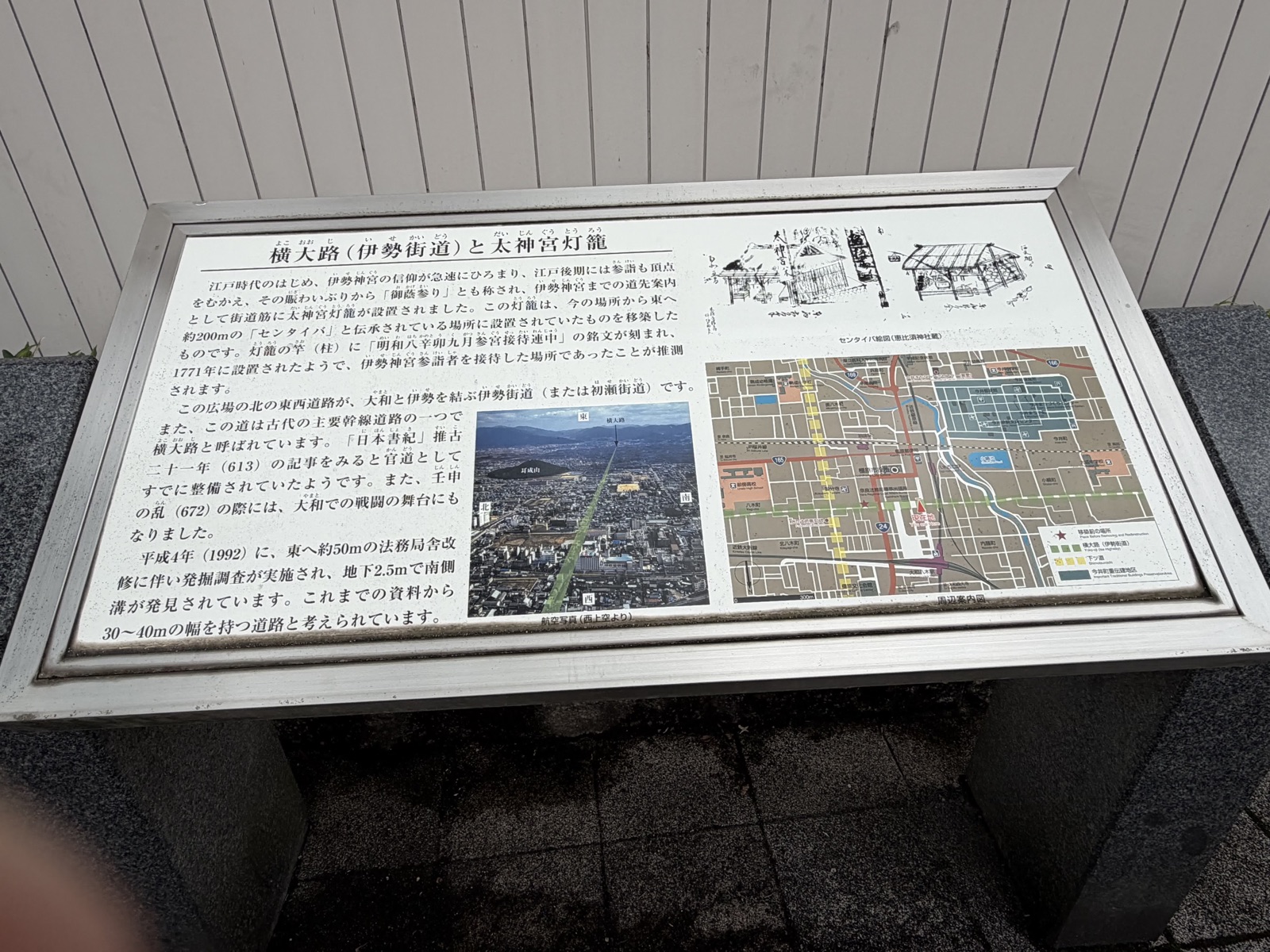 「横大路（伊勢街道）と太神宮灯籠」と題した金属枠の説明板。解説文の横に上空からの航空写真と周辺案内図